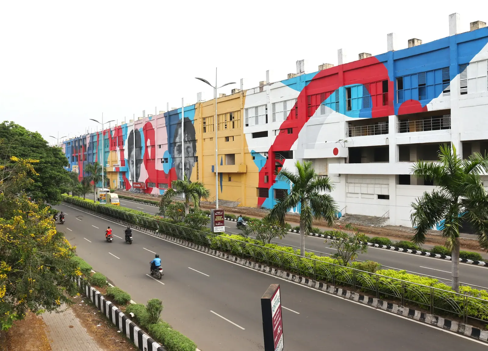 A Chennai street lined with a colourful mural on a building