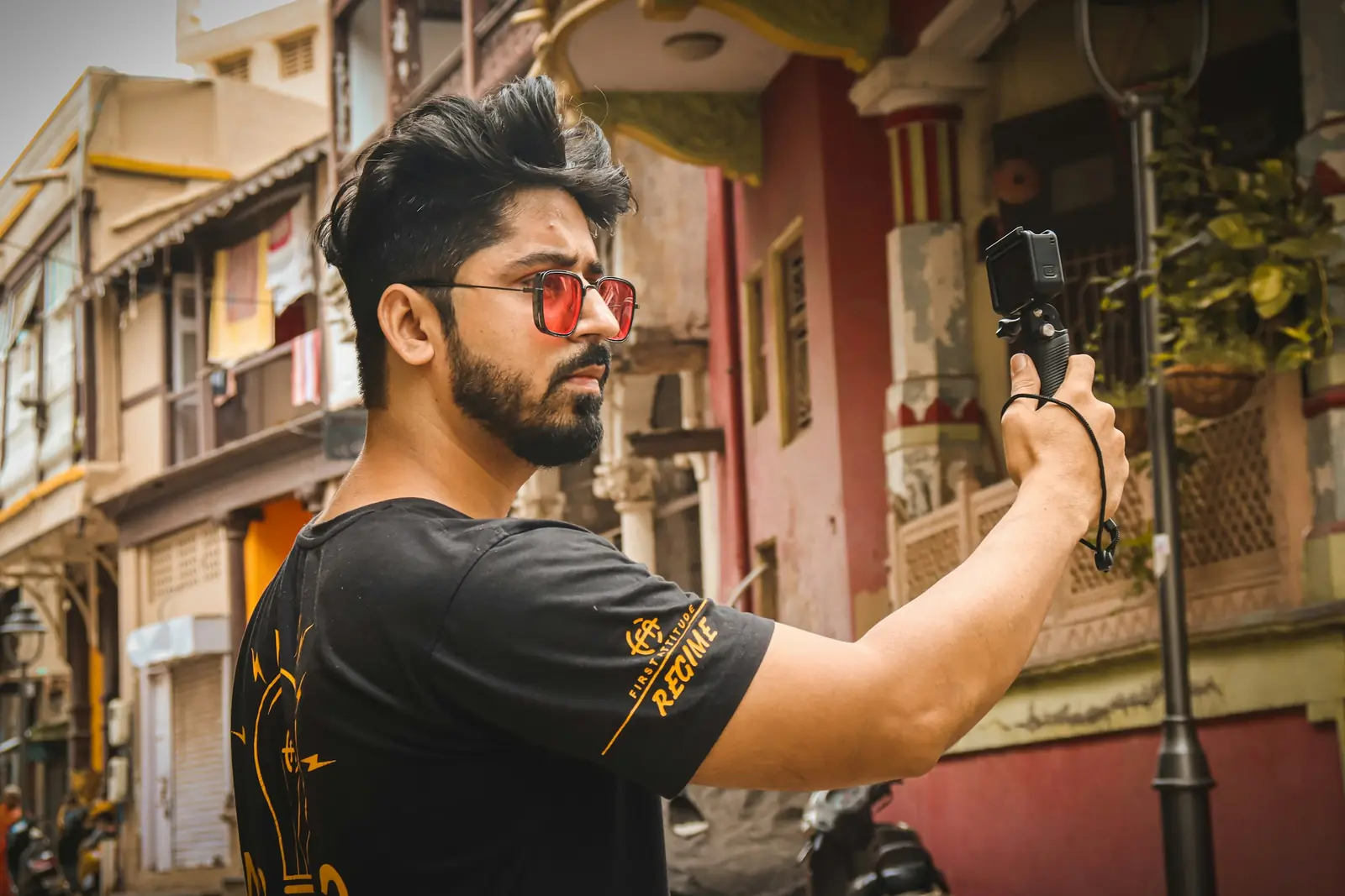 A young man vlogging on a street with a camera held at arm's length